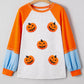 Halloween pumpkin print long sleeve t-shirt with orange raglan sleeves and blue cuffs.