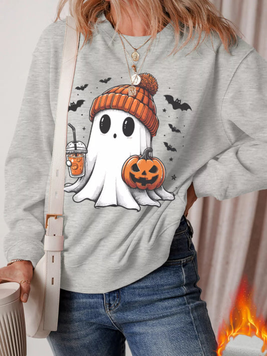 A woman wears a gray sweatshirt with a ghost, pumpkin, and bats design.