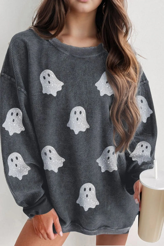 A woman wears a dark gray long-sleeve sweatshirt with glitter ghost graphics.