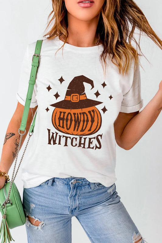 A woman wears a white "HOWDY WITCHES" t-shirt with a pumpkin and witch hat design.