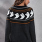 A woman from behind wears a black long-sleeve sweater with a ghost pattern.