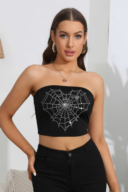 A woman wears a black tube top with a rhinestone heart spider web graphic.