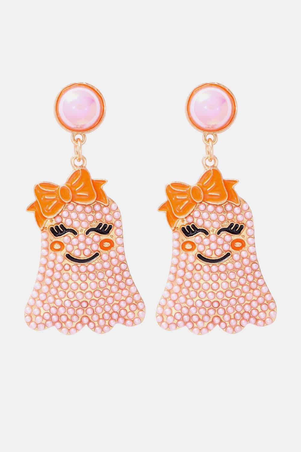 Two pink ghost-shaped earrings with orange bows and smiling faces.