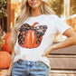 A woman wears a white short-sleeve t-shirt with a pumpkin graphic.