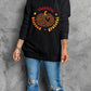 A woman wears a black long-sleeve sweatshirt with a "thankful blessed grateful" pumpkin graphic.