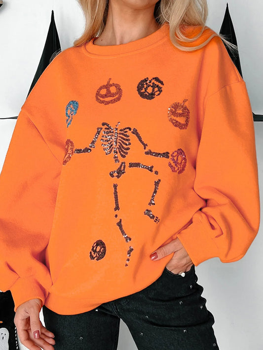 Orange Halloween sweatshirt with a sequin skeleton and pumpkins.