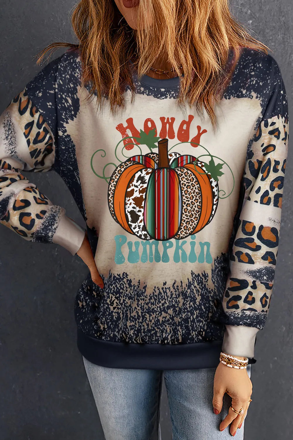 A woman wears a long-sleeve sweatshirt with a "Howdy Pumpkin" graphic.