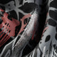 Close-up of a black fabric with white, grey, and pink graffiti-style print.