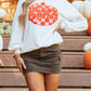 A woman wears a white long-sleeve sweatshirt with a "Hello Pumpkin" patch.