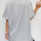 A woman from behind wears a gray round neck short sleeve t-shirt and black shorts.