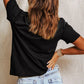 A woman from behind wearing a black t-shirt and light wash denim shorts.