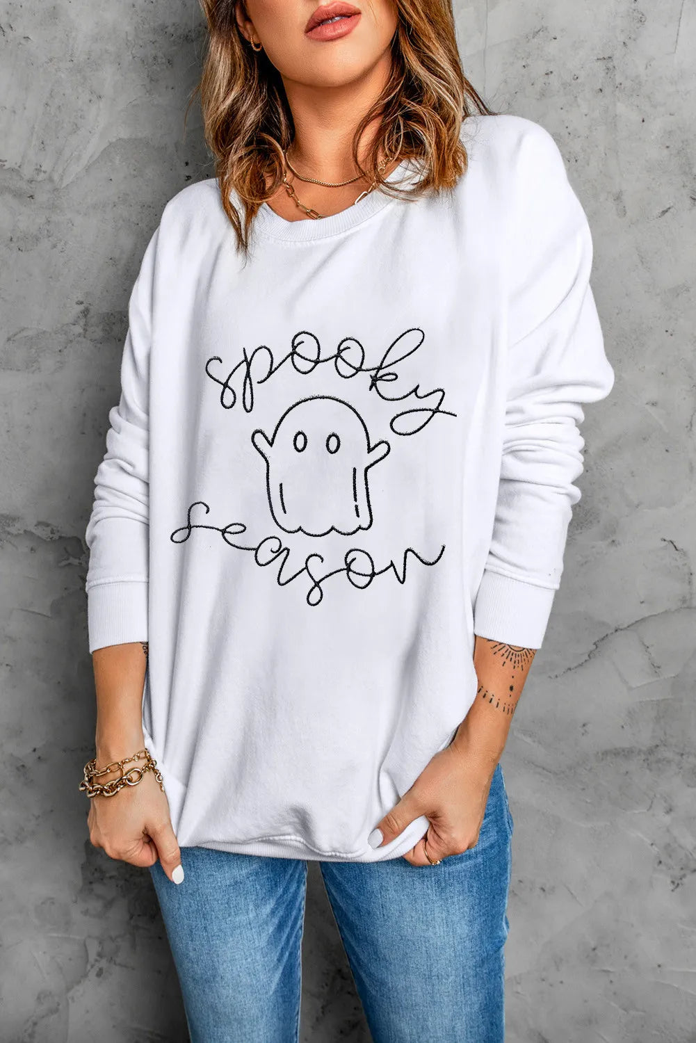 White long sleeve dropped shoulder sweatshirt with a "spooky season" ghost graphic.