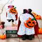 Two sequined Halloween figures with red capes, holding jack-o'-lanterns.