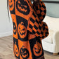 Orange and black pumpkin and checkerboard pattern long sleeve sweater.