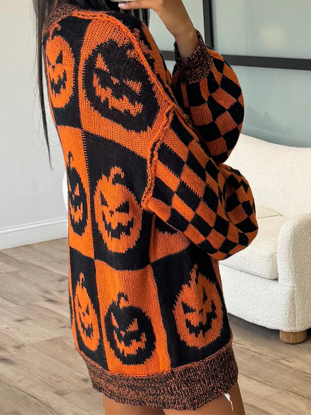 Orange and black pumpkin and checkerboard pattern long sleeve sweater.