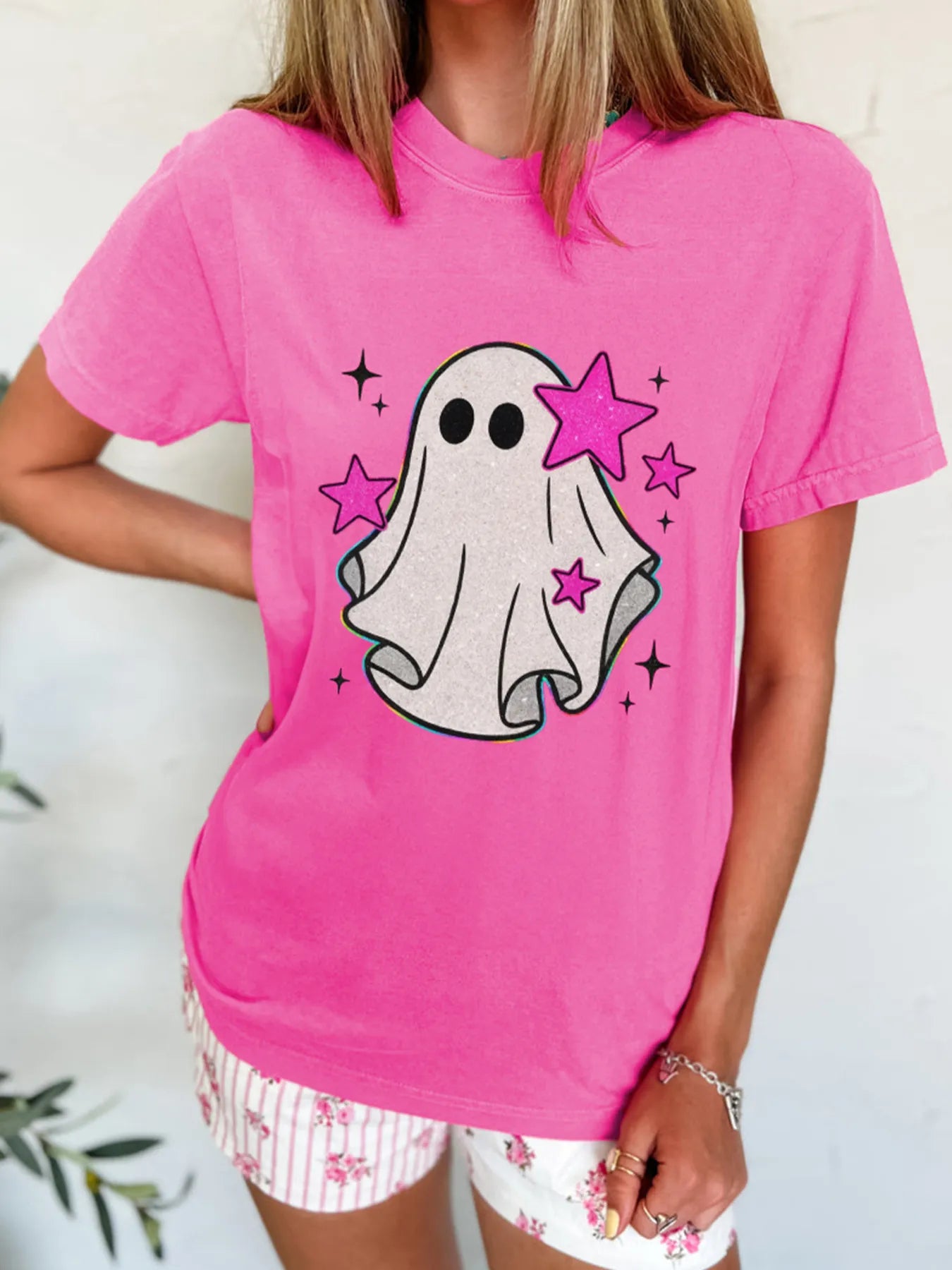 Pink t-shirt with a ghost graphic and pink stars.