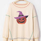 Cream sweatshirt with a sequin pumpkin wearing a witch hat and contrast stitching.