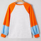 White long-sleeve t-shirt with orange raglan sleeves and light blue cuffs.