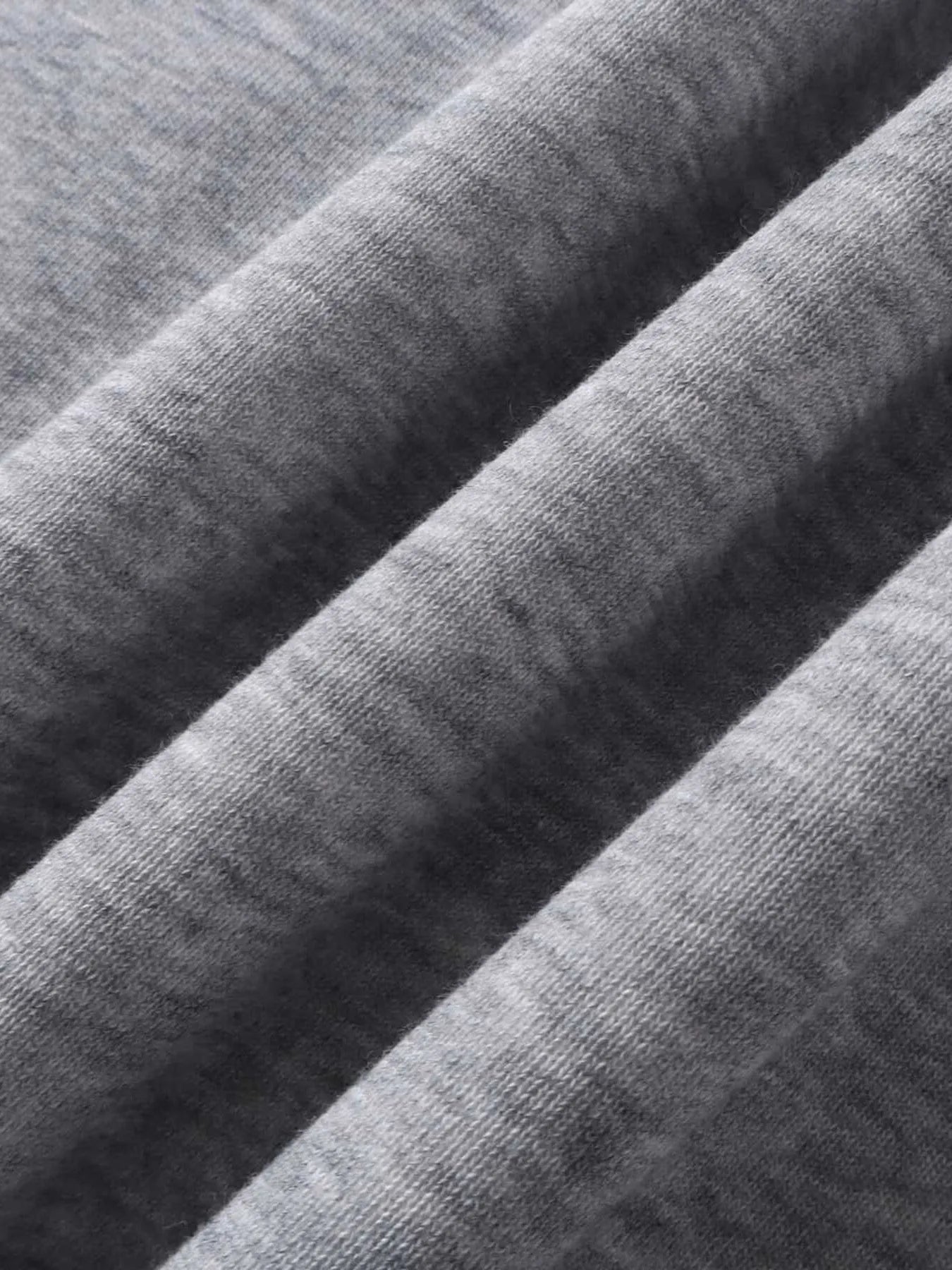 Close-up of the gray fabric of the hoodie, showing its texture and folds.