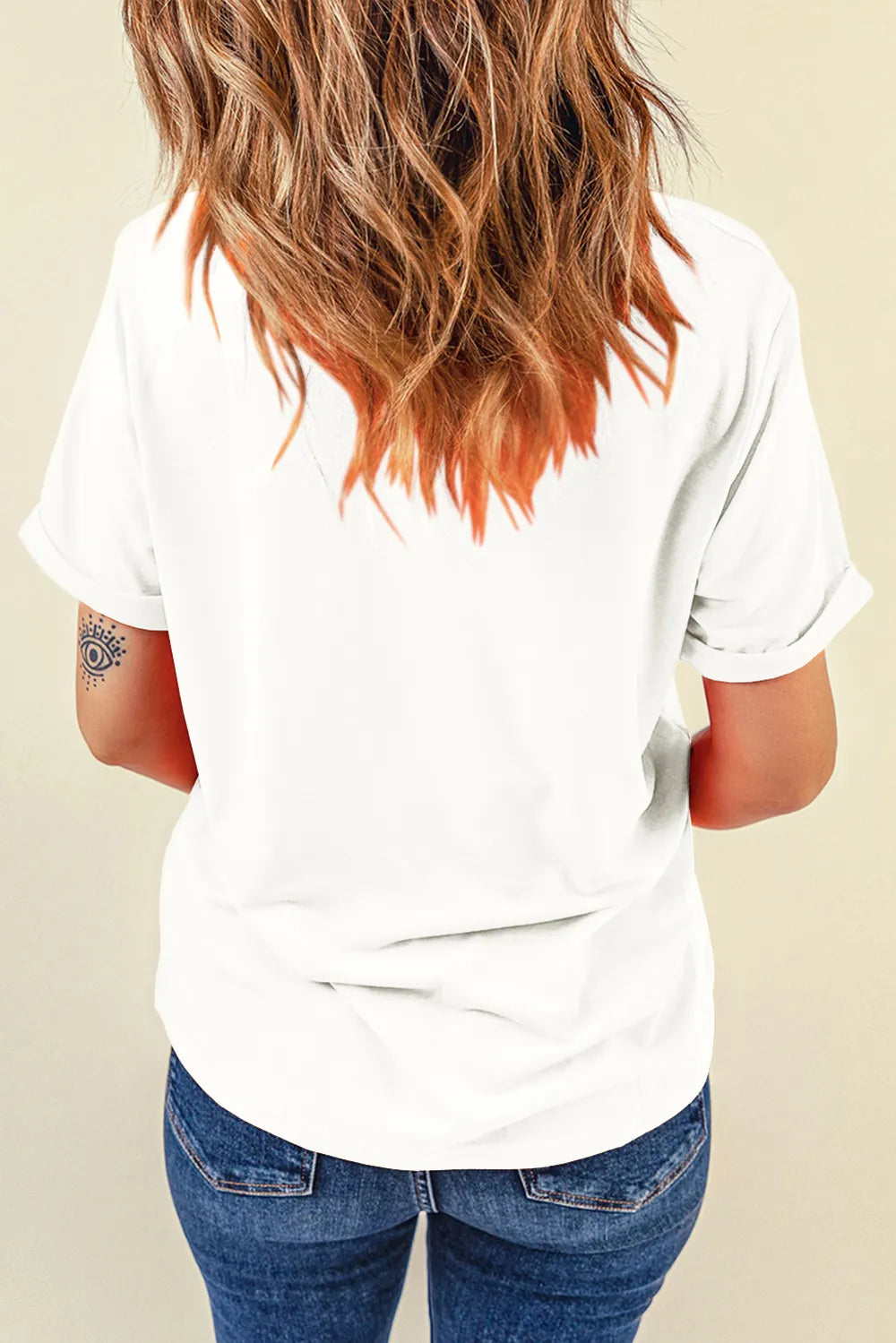Back view of a woman wearing a white short-sleeve t-shirt and blue jeans.