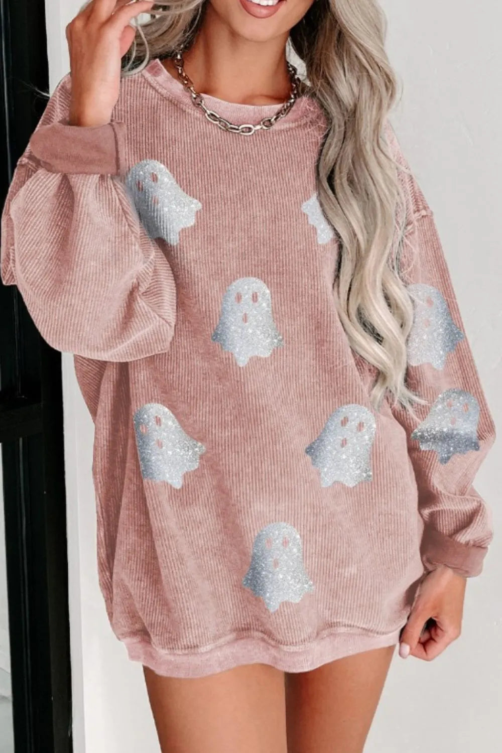 Oversized pink corduroy sweatshirt with glitter ghost graphics.
