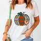 A woman wears a white short-sleeve t-shirt with a leopard print pumpkin graphic.