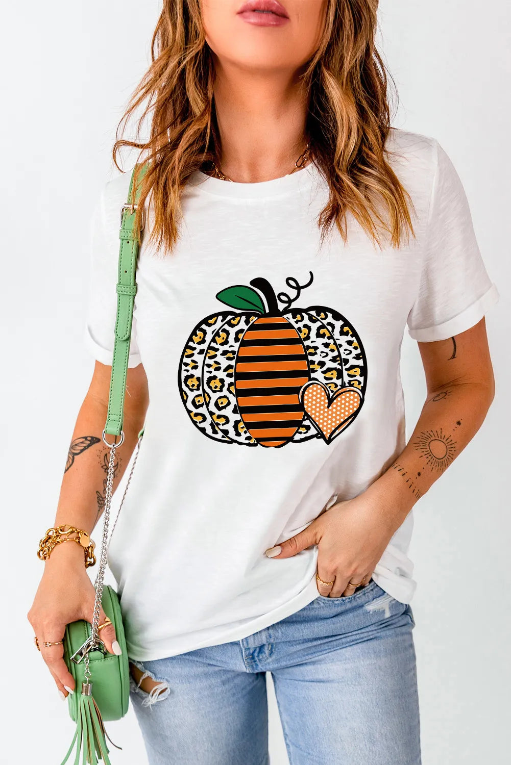 A woman wears a white short-sleeve t-shirt with a leopard print pumpkin graphic.