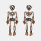 Skeleton-shaped dangle earrings adorned with clear, brown, and black glass stones.