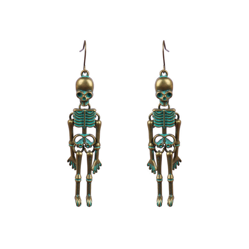 Two antique bronze skeleton earrings with teal accents hang against a white background.