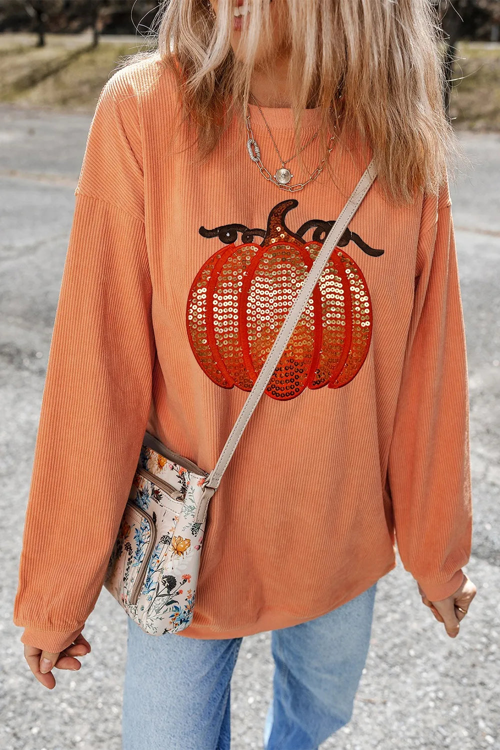 Orange corduroy long-sleeve sweatshirt with a sequin pumpkin design.