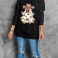 Black long-sleeve sweatshirt with a ghost wearing a cowboy hat and peace signs.