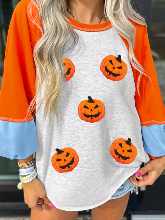 Halloween pumpkin print long sleeve t-shirt with orange sleeves and light blue cuffs.
