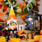 Two Halloween gnome ornaments, one with a lollipop and one with a cat and broom.