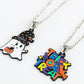 Two silver-colored chain necklaces with Halloween-themed pendants, one a ghost and one "Trick or Treat."