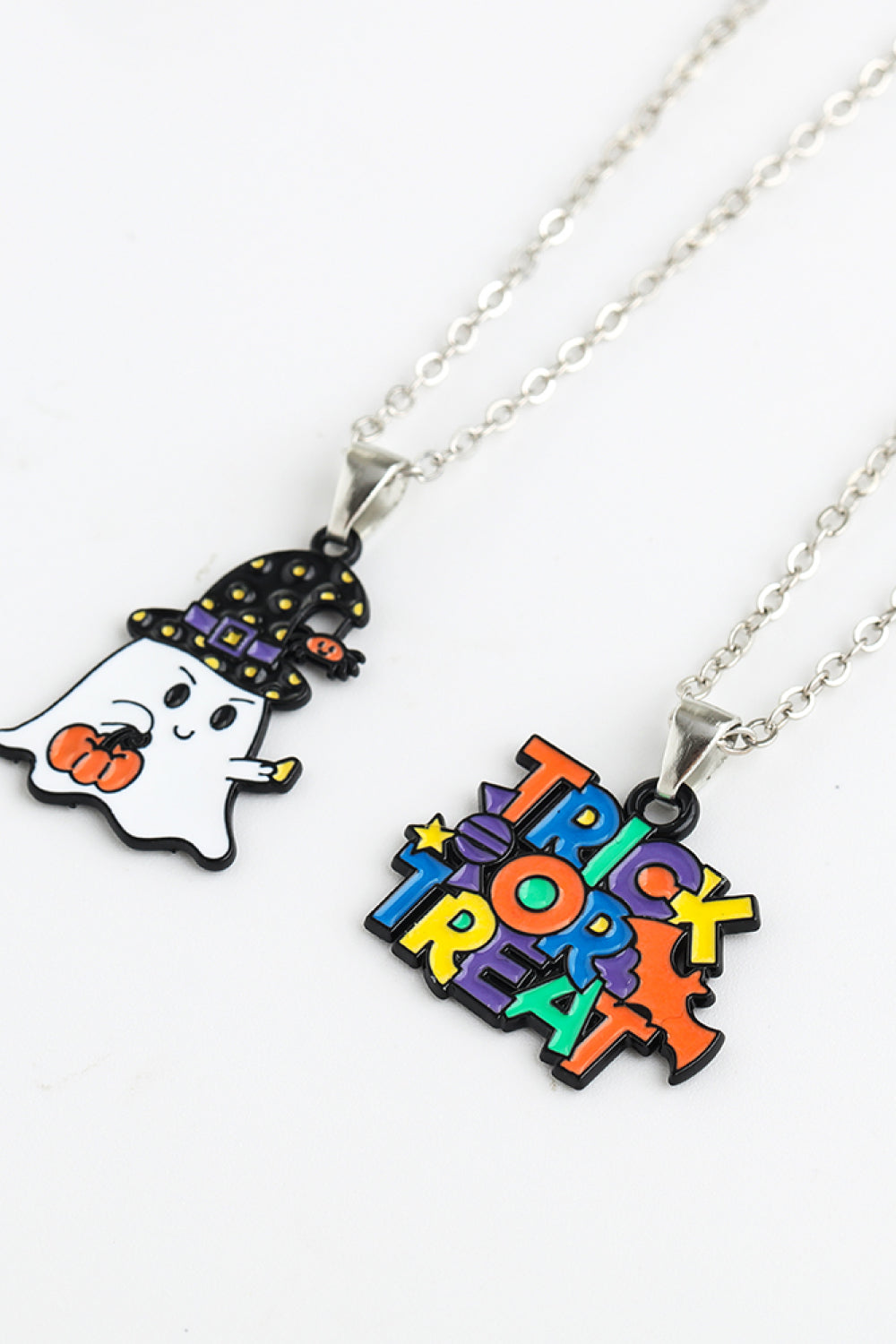 Two silver-colored chain necklaces with Halloween-themed pendants, one a ghost and one "Trick or Treat."
