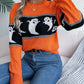 Orange long-sleeve sweater with a black and white ghost pattern.