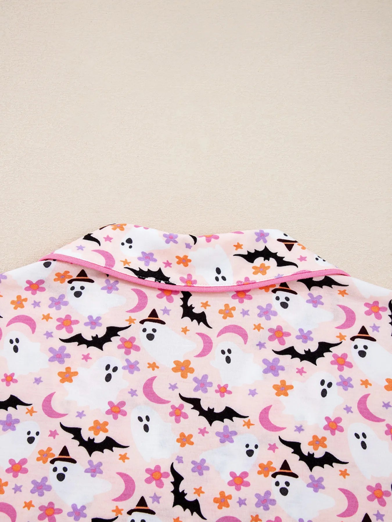 Pink Halloween ghost print button-up top with a collar.