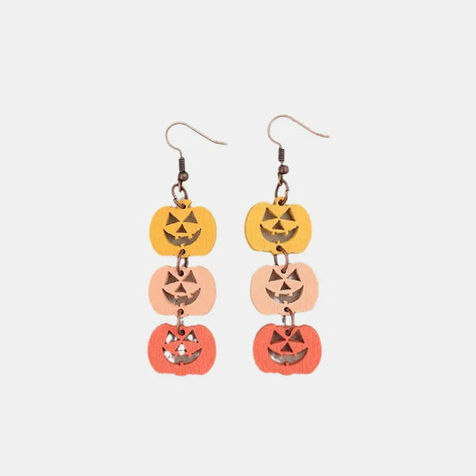 Wooden dangle earrings feature three stacked pumpkins in yellow, peach, and orange.