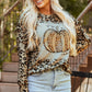 A woman wears a leopard print long-sleeve sweatshirt with a pumpkin graphic.