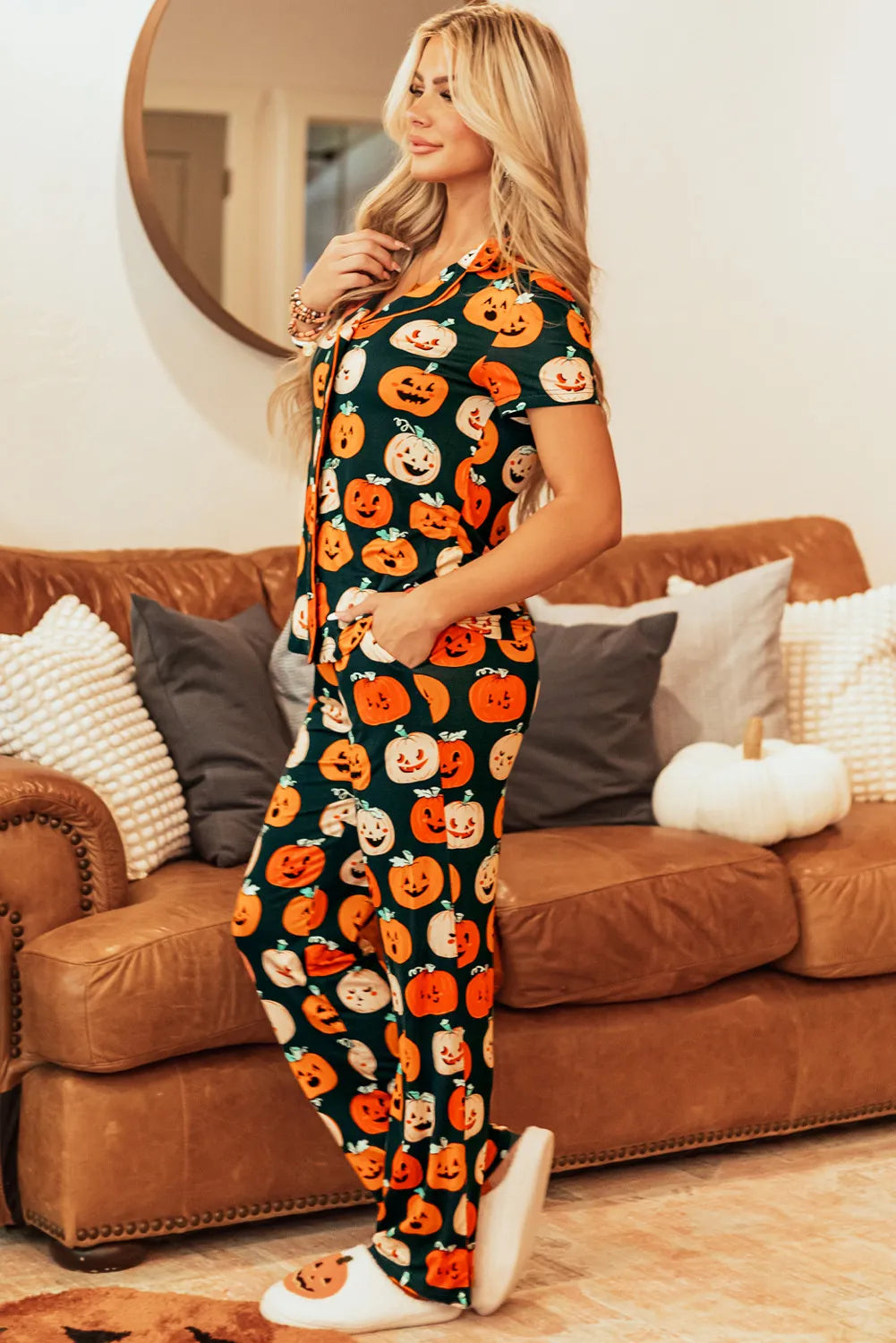 A woman models a pumpkin-printed short sleeve top and pants lounge set.