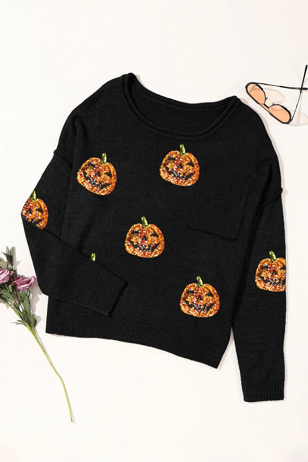 Black knit top with sequin pumpkins and a round neck.