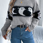 A woman wears a gray long-sleeve sweater with a black and white ghost pattern.