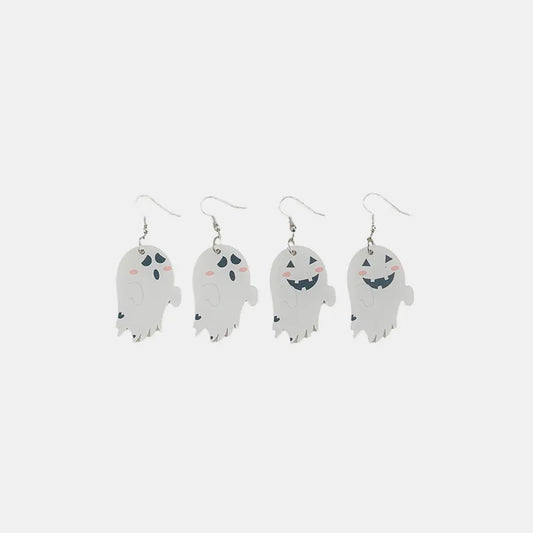 Two pairs of white ghost dangle earrings, one pair with simple faces, the other with smiling jack-o'-lantern faces.