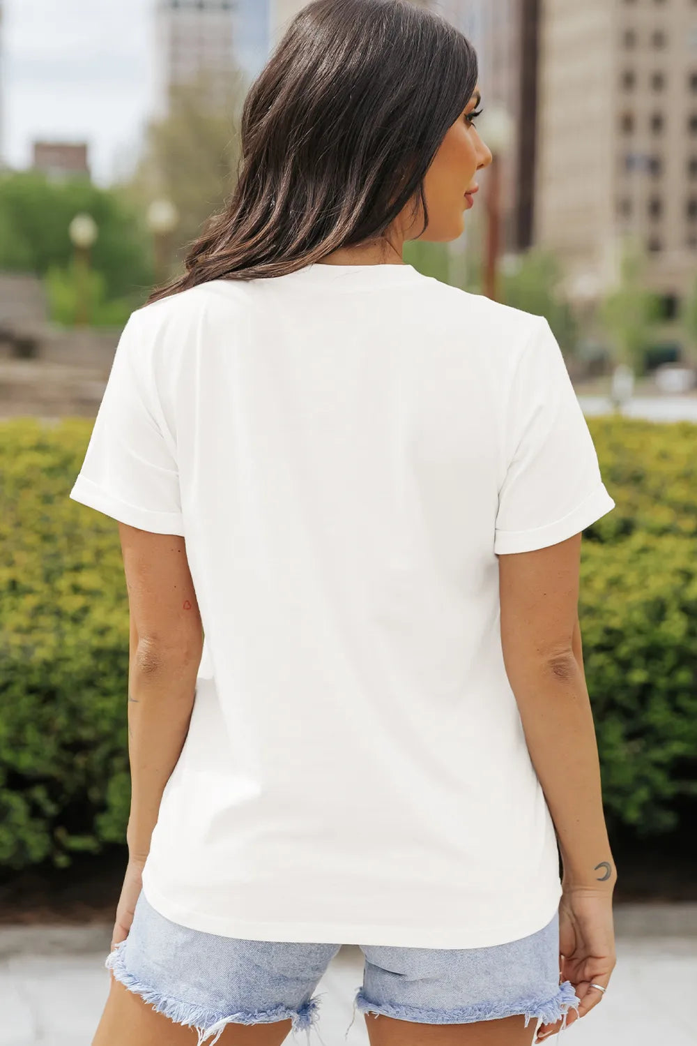 White short-sleeve t-shirt with a round neck, worn by a woman facing away.