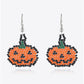 Two beaded Halloween pumpkin earrings with orange, black, and green beads.