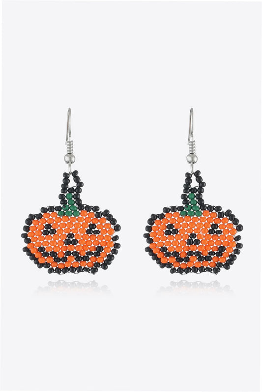 Two beaded Halloween pumpkin earrings with orange, black, and green beads.