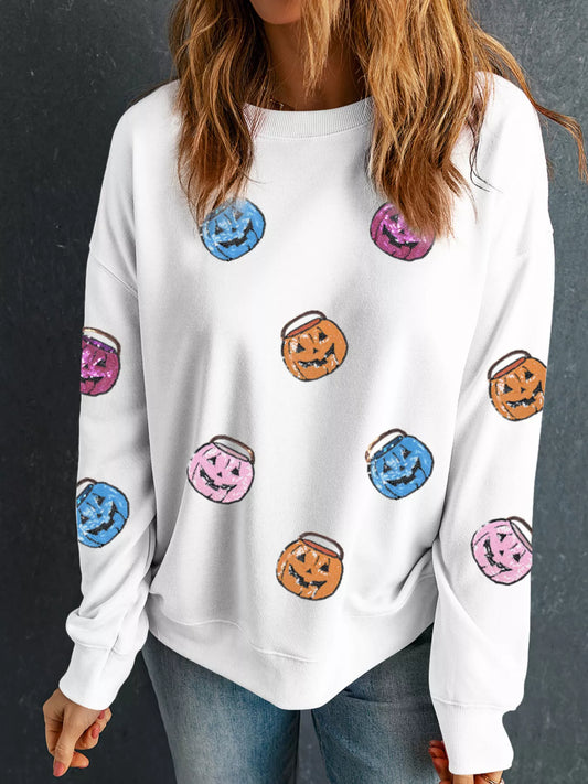 White sweatshirt with colorful sequin pumpkin lantern patches.