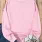 Pink round neck long sleeve sweatshirt with jeans and leopard print sneakers.