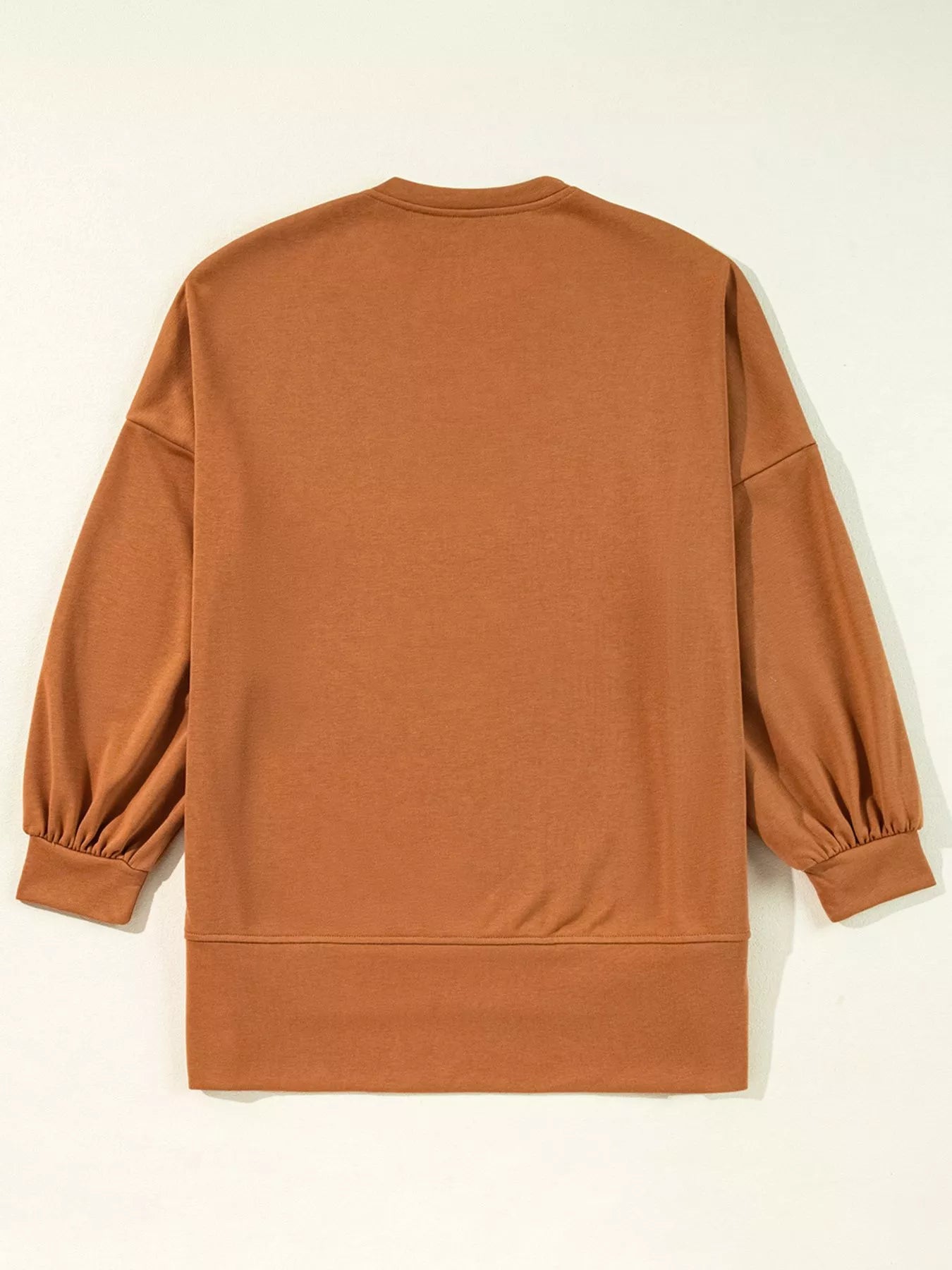 Brown long-sleeve loose top with gathered cuffs and a ribbed hem.