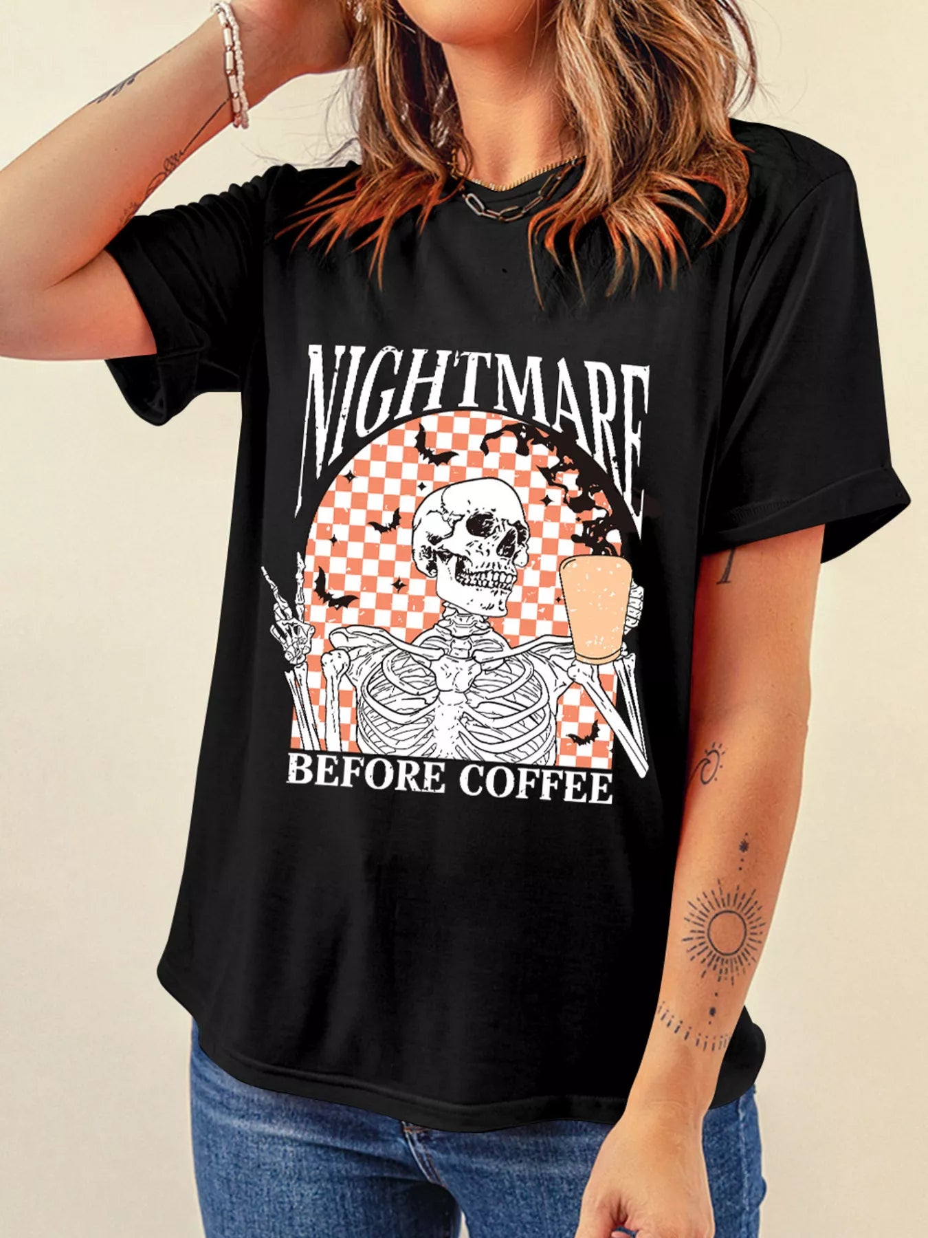 A woman wears a black tee with a skeleton and "NIGHTMARE BEFORE COFFEE" graphic.